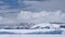 Antarctica with towering snow covered mountains, glaciers time lapse aerial. Large snow-capped mount