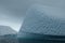 Antarctica unique blue iceberg art texture beneath cloudy sky. snowy mountains