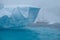 Antarctica unique jagged blue streaked iceberg with sailboat