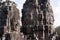 Anthropomorphic faces carved into stone at the Bayon Wat in late afternoon light, a 12th century temple with