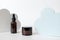 Anti-aging collagen facial cream and hyaluronic acid serum in brown glass bottle with dropper and cloud shape decor