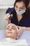 Anti-aging facial. Model receives physiotherapy, procedure of de-sonvalization. Beauty salon, cosmetology. Model and Doctor, close