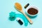 Anti-cellulite dry body massage brush, aromatherapy oil, massager and coffee scrub on blue background. Lymphatic drainage body