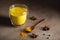 Anti- flu Golden milk with turmeric powder in glass over dark grunge background, copy space. Health and energy boosting, flu remed