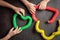 anti stress sensory pop tube toys in a children`s hands. a little happy kids plays with a poptube toy on a black table. toddlers