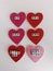 Anti valentine words on pink and red hearts on a white background