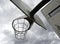 An anti-vandal basketball hoop with iron chains against a gloomy cloudy sky