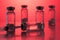 Antibiotic injection bottles with a plastic disposable syringe on a red background