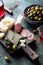 Antipasto board with sliced salami, goat cheese, assorted olives and red wine