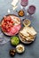 Antipasto. Meat platter, chips and sauces, red wine on gray background. Top view