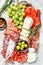 Antipasto platter cold meat with grapes, prosciutto, slices ham, beef jerky, chorizo salami, fuet, Camembert and goat cheese. Gray