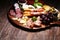 Antipasto various appetizer. Cutting board with prosciutto, salami, cheese, bread and olives on dark wooden background