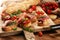 Antipasto various appetizer. Cutting board with prosciutto, salami, cheese, bread and olives on dark wooden background