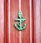 Antique anchor shaped knokcer on a red vintage door