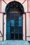 Antique architecture, old vintage closed black iron door with a massive handle, entrance to the staircase with an arch