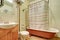 Antique bathroom interior with brown bath tub and hardwood floor