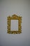 Antique Beautiful golden decorated picture frame with blank space on white wall close-up. Copy space