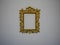 Antique Beautiful golden decorated picture frame with blank space on white wall close-up. Copy space