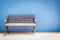 Antique bench with blue concrete wall