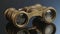 Antique binoculars on a reflective studio background