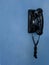 antique black wall phone hung on a wall blue