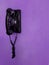 antique black wall phone hung on a wall purple