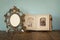 Antique blank victorian style frame and old open photograph album with vintage necklace on wooden table. retro filtered image
