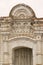 Antique brick arch over a wooden door with patterns. Beautiful old arch over the entrance. Made at the beginning of the last centu