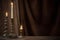 antique candlestick with burning candle on wooden table on background brown velvet curtain