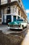 Antique car with reflections on a water puddle in Old Havana