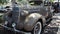 Antique car with rocket emblem and grills in front and sides, suicide doors