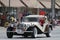 Antique car with roof with American Flags in parade in small town America