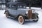 An antique car in the snow in New England