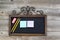Antique chalkboard with supplies on rustic wood