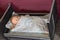 Antique child`s doll in a tiny bed