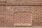 Antique clay exterior brick wall background with bricked in basement windows along a sidewalk