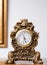 Antique clock in golden colors decorated with ornaments