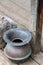 Antique copper spittoon on wood deck next to weathered wood post