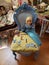 Antique doll on a blue fancy chair