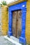 Antique doorway in Greek island painted yellow and blue