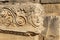 Antique frieze with stone-cut mask in the ruins of the ancient city of Myra, Turkey