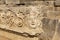 Antique frieze with stone-cut mask in the ruins of the ancient city of Myra, Turkey