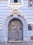 An antique front door with beautiful stucco molding in the form of a mans head