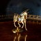 Antique gold figurine of a horse in a luxurious interior.
