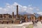 Antique italian square with tourists and ruins against volcano Vesuvius in Pompeii, Italy. Ancient forum concept.