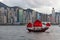 Antique junk boat with tourists in Victoria Harbour, Hong Kong, skyline of buildings in background