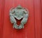 Antique knocker on a red wooden door