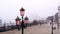 Antique lamp post stands on bricked seafront by lagoon