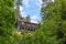 An antique looking structure surrounded by a dense forest