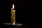 Antique metal candlestick with burning candle